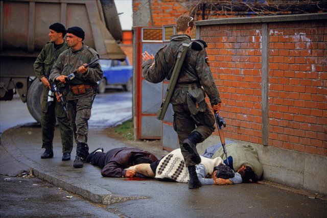 Arkan egyik katonája kivégzett muzulmánok holttestét rugdossa az utcán a boszniai Bijeljinában